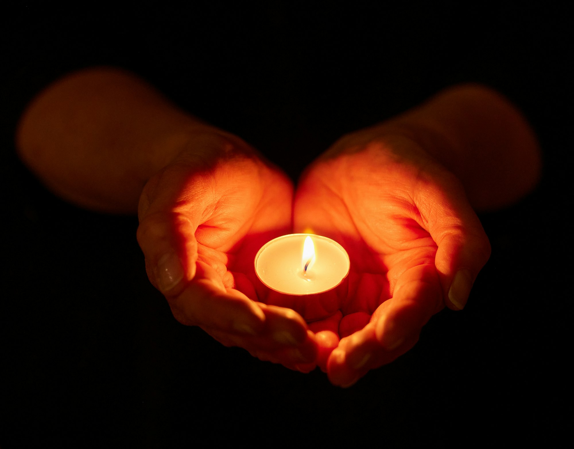 We have always held to the hope. Shot of a unrecognizable person holding a candle in the dark.