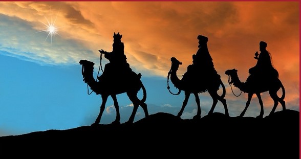 Silhouettes of three camels with riders against a dramatic sky, near a bright star on the left, creating a magic night scene.