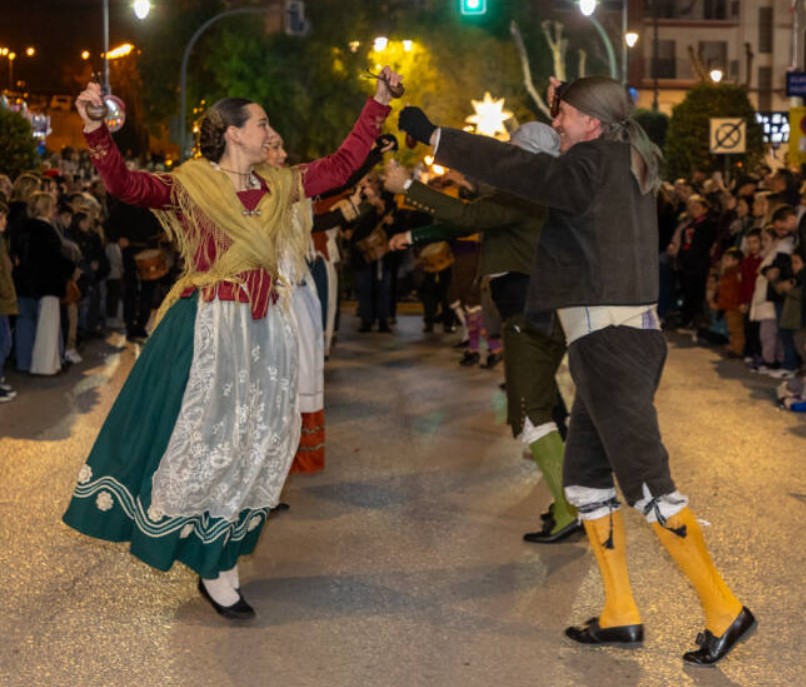 Performers in traditional Alcoy attire started to dance joyfully on the street, surrounded by a crowd watching the night event.