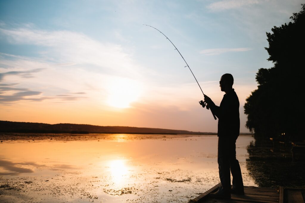 Fishing. spinning at sunset. Silhouette of a fisherman.
