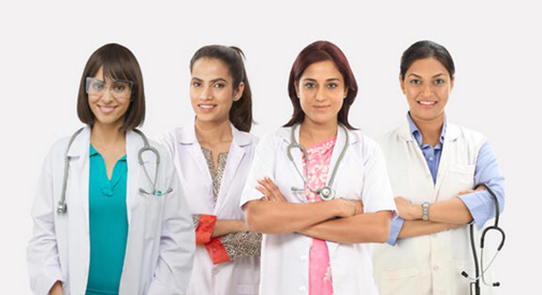 Four female doctors stand side by side in their white coats and stethoscopes, exuding the fierce confidence of a tiger, arms crossed as they pose together against a plain white background—ready to take on any challenge in the ward.
