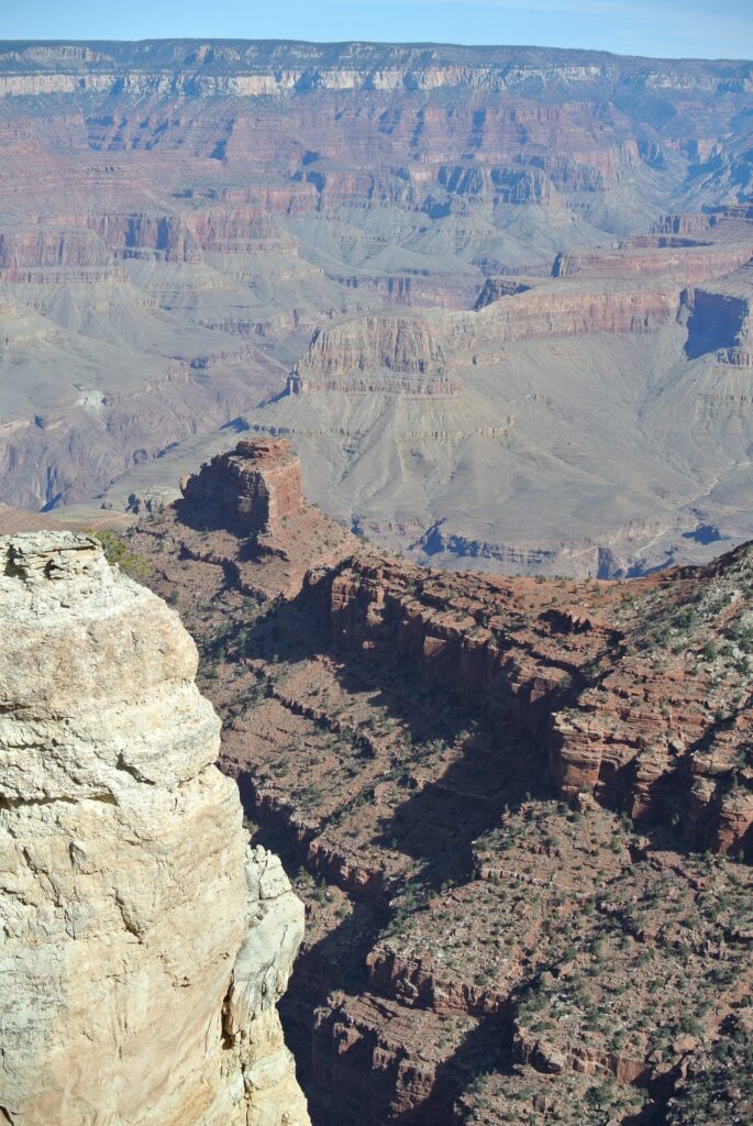 Travel to the Grand Canyon and witness stunning layered rock formations, steep cliffs, and deep valleys—all perfect to explore from the comfort of your SUV under a clear blue sky.